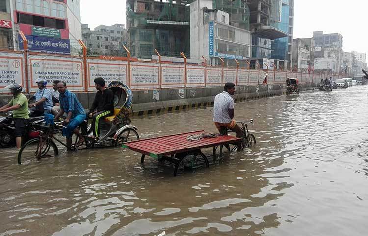 হাঁটু সমান পানি দিয়ে চলছে ঠেলাগাড়ি ও রিকশা। ছবি : আবু সালেহ সায়াদাত