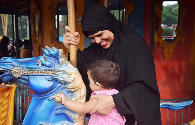 শিশুপার্কে সন্তানকে নিয়ে ঘুরতে এসেছেন এক মা। ছবি : মাহবুব আলম