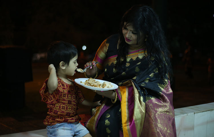 সন্তানকে খাবার খাওয়াতে ব্যস্ত এক মা। ছবি : মাহবুব আলম