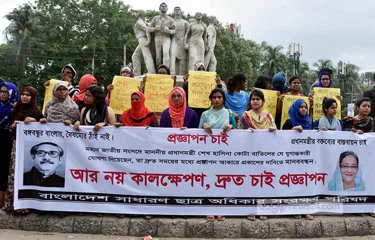 রাজু ভাস্কর্যের সামনে ব্যানার নিয়ে দাঁড়িয়েছে ছাত্রীরা। ছবি : বিপ্লব দিক্ষিৎ