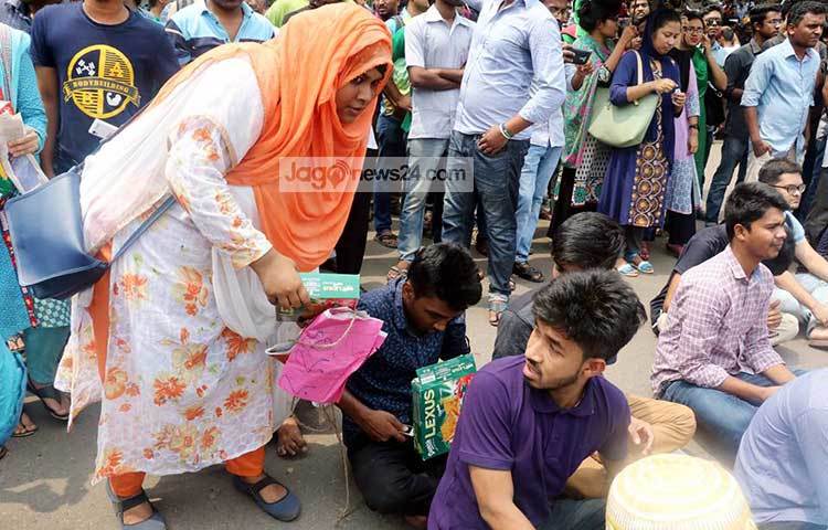 আন্দোলনরত ছাত্র-ছাত্রীদের মাঝে বিস্কুট বিতরণ করছেন এক ছাত্রী। ছবি : বিপ্লব দিক্ষিৎ