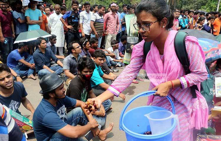 আন্দোলনরত ছাত্র-ছাত্রীদের মাঝে খুরমা খেজুর বিতরণ করছেন এক ছাত্রী। ছবি : বিপ্লব দিক্ষিৎ