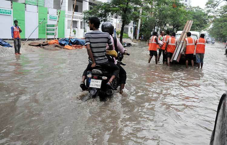 রাস্তার পানির মধ্যে মনে হচ্ছে জলযান চলছে। ছবি : বিপ্লব দিক্ষিৎ