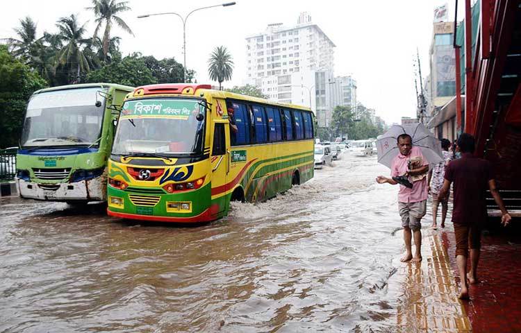 রাস্তা পানিতে ডুবে যাওয়ায় পথচারীরা দুর্ভোগে পড়েছে। ছবি : বিপ্লব দিক্ষিৎ