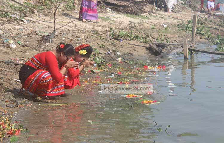 সবার মঙ্গল কামনায় ফুল ভাসিয়ে দিয়েছেন দুই নারী।