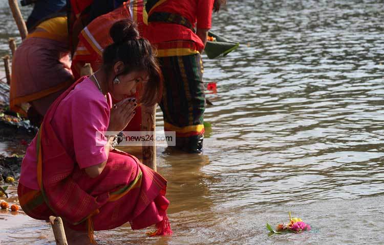 জীবনের সুখ সমৃদ্ধি কামনায় ফুল ভাসিয়ে প্রার্থনা করছেন এক নারী।