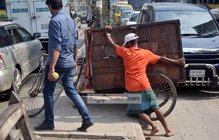 দুই দিক দিয়ে যাচ্ছে গাড়ি। এর মধ্যেই ময়লা নেয়ার গাড়ি ঠেলে নিয়ে যাওয়ার চেষ্টা চলছে। এতে করে যে কেনো মুহূর্তে ঘটতে পারে দুর্ঘটনা। ছবি : মাহবুব আলম