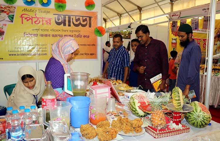 পিঠার আড্ডার স্টলে দর্শকরা কেটাকাটায় ব্যস্ত। ছবি : বিপ্লব দিক্ষিৎ