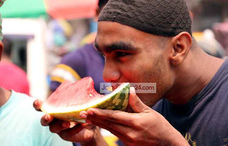 প্রাণ ভরে তরমুজ খাচ্ছেন একজন। ছবি : বিপ্লব দিক্ষিৎ