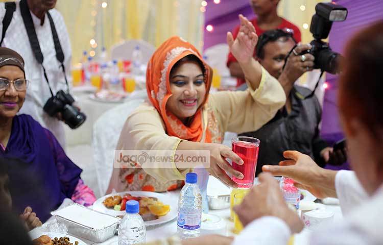 শাবনূর ইফতারের জন্য একজনের হাতে শরবত তুলে দিচ্ছেন। ছবি : মাহবুব আলম