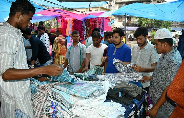 ফুটপাতের কেনাকাটায় মাঝে মধ্যে বৃষ্টি বিড়ম্বনার সৃষ্টি করে। তাই দোকানে পলিথিন টাঙিয়ে নেয়া হয়েছে। ছবি : বিপ্লব দিক্ষিৎ
