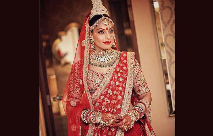 বিপাশা বসু বিয়ের দিন পরেছিলেন সোনালি-লাল বেনারসী লেহেঙ্গা। এটির দাম ছিল প্রায় চার লক্ষের কাছাকাছি।