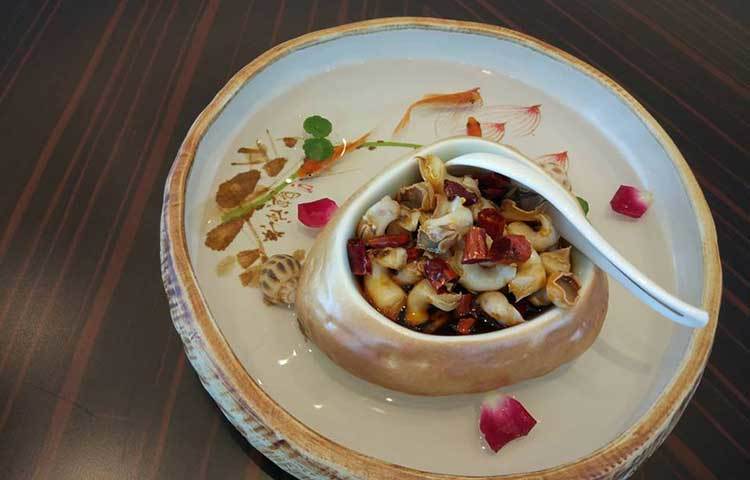 খাবার পরিবেশনের ক্ষেত্রে বিশেষ গুরুত্ব দেয় চীনারা। এই ছবিটি তার ভালো উদাহরণ হতে পারে। খাবার চারপাশের পানিতে ঘুরে বেড়াচ্ছে গোল্ড ফিস আর শামুক। তবে এগুলো খাওয়ার জন্য নয়। কেবলই পরিবেশনে বাড়তি আকর্ষণের জন্য।