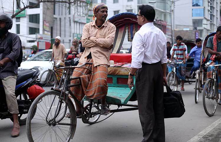 রিকশা চালকের সঙ্গে দর কষাকষি করছেন অফিসগামী এক ব্যক্তি। সাধারণ ভাড়ার চেয়ে কয়েক গুণ বেশি ভাড়া যাচ্ছে চালক। ছবি : মাহবুব আলম