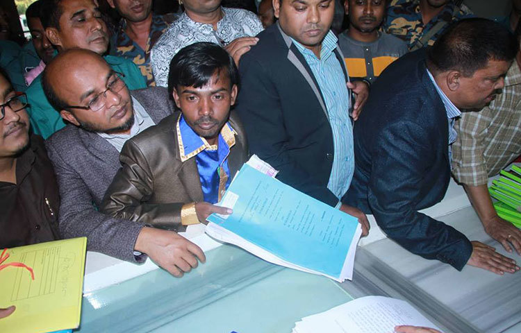 কমিশনের কাছে কাগজপত্র জমা দিচ্ছেন হিরো আলম। ছবি : মাহবুব আলম