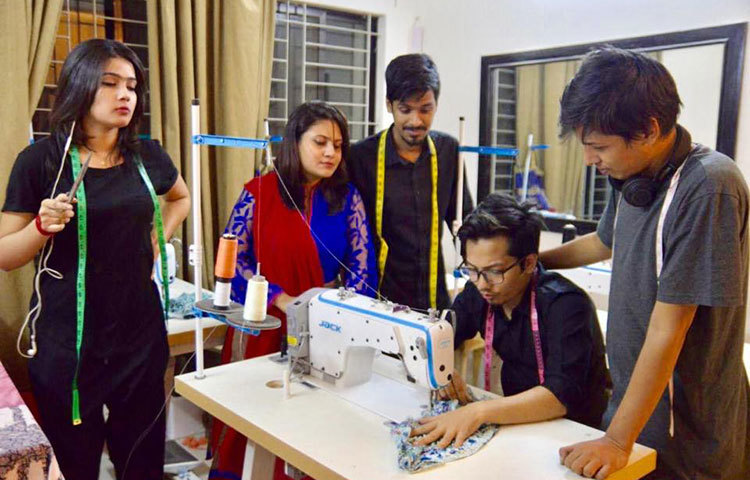 দাঁড়িয়ে পোশাক তৈরির কাজের নির্দেশনা দিচ্ছেন মাহি।