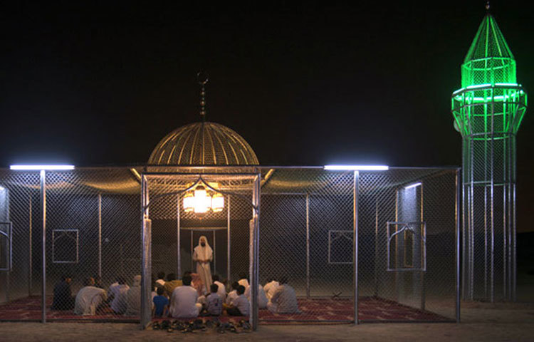 রাতে বৈদ্যুতিক আলোয় আলোকিত কাঁচে নির্মিত মসজিদ।