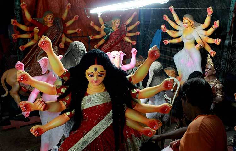 প্রতিমার গায়ে তুলির শেষ আচড় দিচ্ছেন প্রতিমা শিল্পী। ছবি : মাহবুব আলম