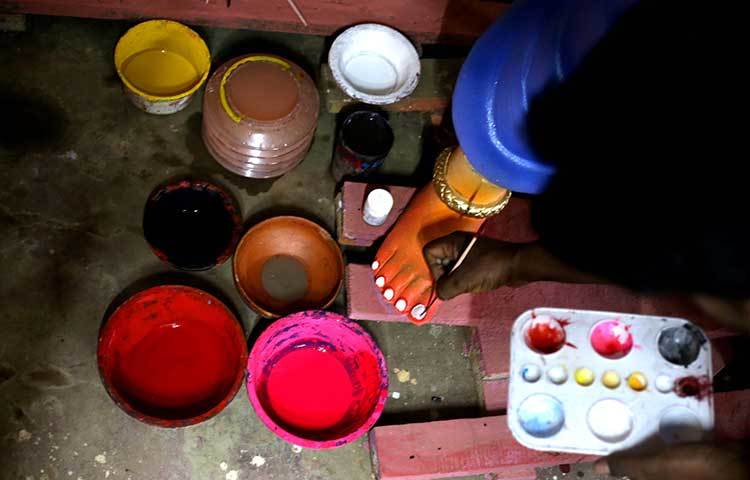 পা সাজাতে ব্যস্ত প্রতিমা শিল্পী। ছবি : মাহবুব আলম