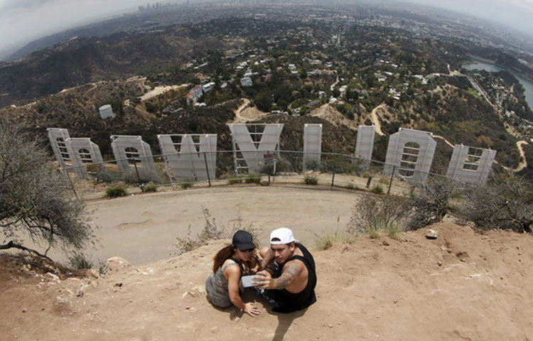 লস এঞ্জেলসে হলিউড লেখা হোর্ডিংয়ের সামনে।