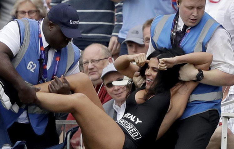 সুইমস্যুট পরে লাফ মেরে মাঠে ঢোকার চেষ্টা করেন ওই মহিলা। পরে পুলিশ তাকে মাঠ থেকে বের করে আনেন।