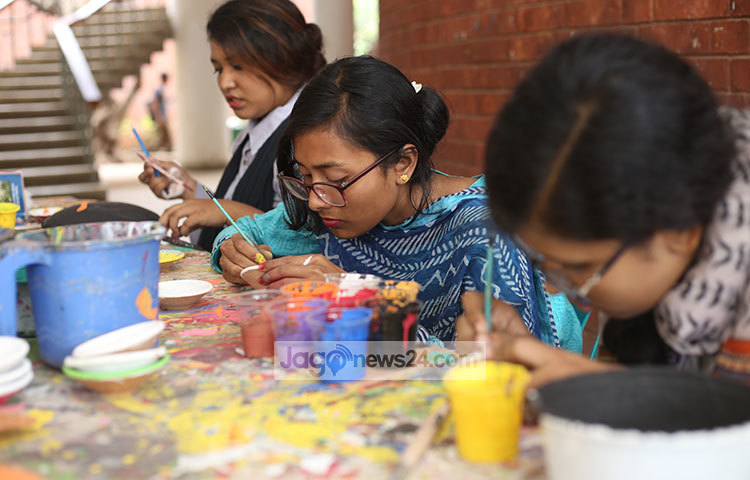 মগ্ন হয়ে মাটির তৈরি জিনিসপত্রে আলপনা আঁকছেন চারুকলার শিক্ষার্থীরা। ছবি: মাহবুব আলম