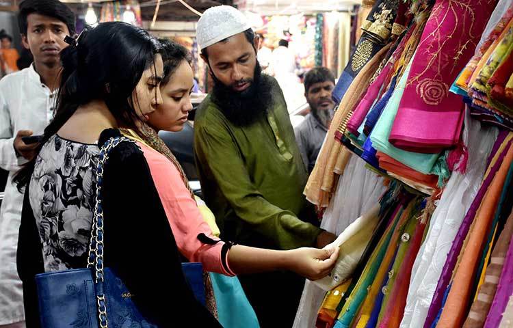 রঙ বাহারি থ্রি পিচ থেকে নিজেদের পছন্দেরটি খুঁজছেন ক্রেতারা। ছবি: বিপ্লব দিক্ষিৎ