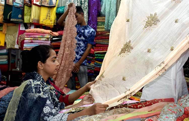 পোশাক বাছাইয়ে ব্যস্ত এ নারী। ছবি: বিপ্লব দিক্ষিৎ