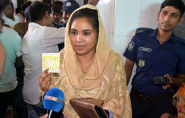 বাড়ি ফেরার প্রত্যাশিত টিকেট পেয়ে দেখাচ্ছেন এক নারী। ছবি: বিপ্লব দিক্ষিৎ