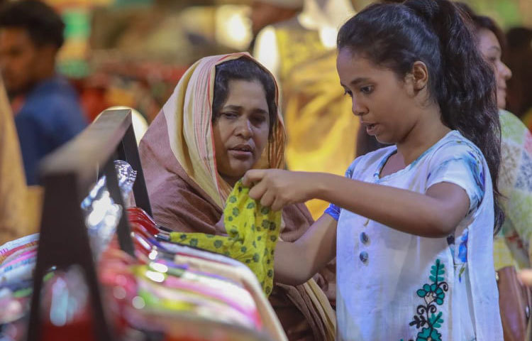 শিশুটি তার নিজের পছন্দের পোশাক খুঁজছে। ছবি: মাহবুব আলম