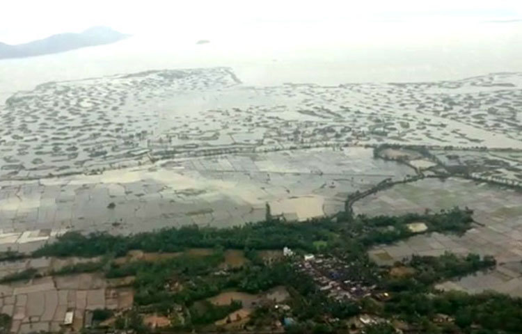 ছবিতে দেখা যাচ্ছে যতদূর চোখ যায় জলে ভরে গিয়েছে। বাড়ি-ঘরের অনেকটাই গ্রাস করেছে জল। জেগে রয়েছে একটিমাত্র বড় রাস্তা।