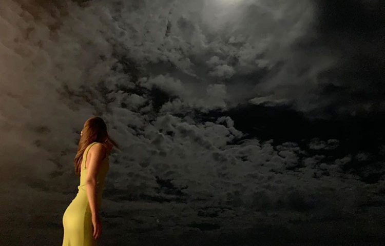 কৃতি মেঘের কোলে সূর্য লুকিয়ে যাওয়ার দৃশ্য দেখছেন।