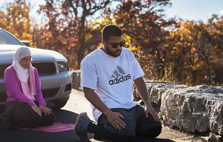 গাড়ি থামিয়ে নামাজ পড়ছেন দুইজন ভ্রমণকারী।