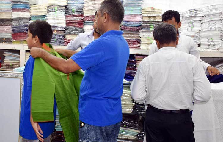 সন্তানের জন্য পাঞ্জাবির মাপ দিচ্ছেন এক বাবা। ছবি: বিপ্লব দিক্ষিৎ