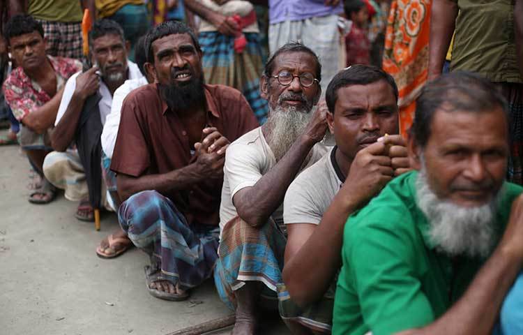ত্রাণ নিতে অপেক্ষা করছেন সারিবদ্ধ মানুষ। ছবি: মহবুব আলম