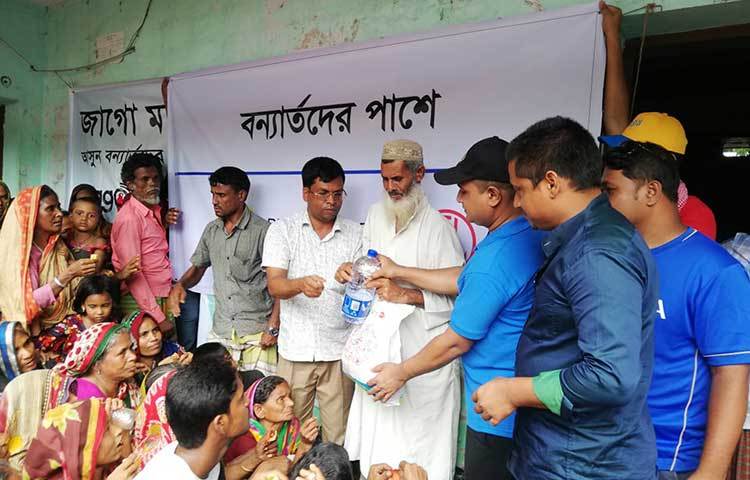 ত্রাণ নিতে আসা সারিবদ্ধ মানুষ। ছবি: মহবুব আলম