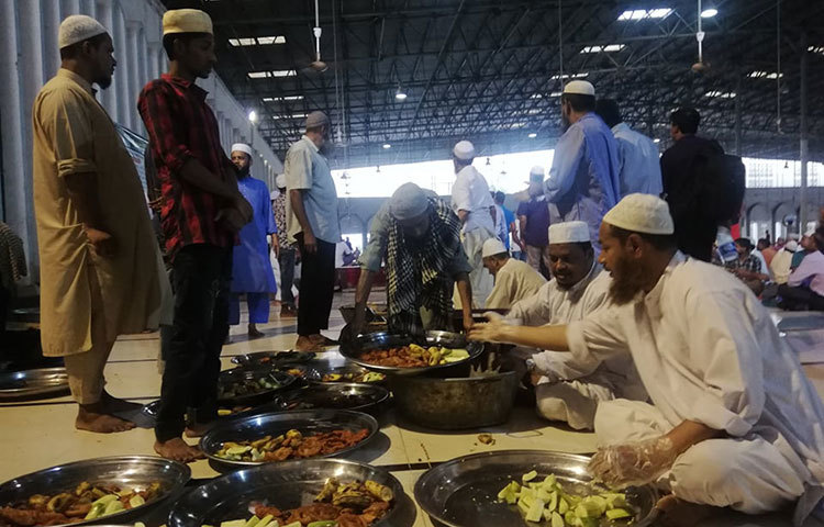 বড় বড় থালায় ইফতারির সামগ্রী বিতরণ করা হচ্ছে। ছবি: মাহবুব আলম