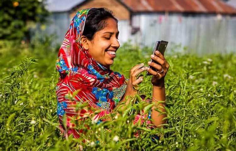 কৃষি কাজের বিভিন্ন তথ্য স্মার্টফোনে জানছেন এক নারী।