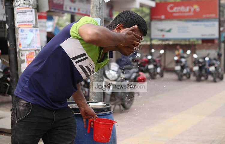 দাবদাহ থেকে বাঁচতে পানি দিয়ে মুখ ধুইছেন এক পথচারী। ছবি: মাহবুব আলম