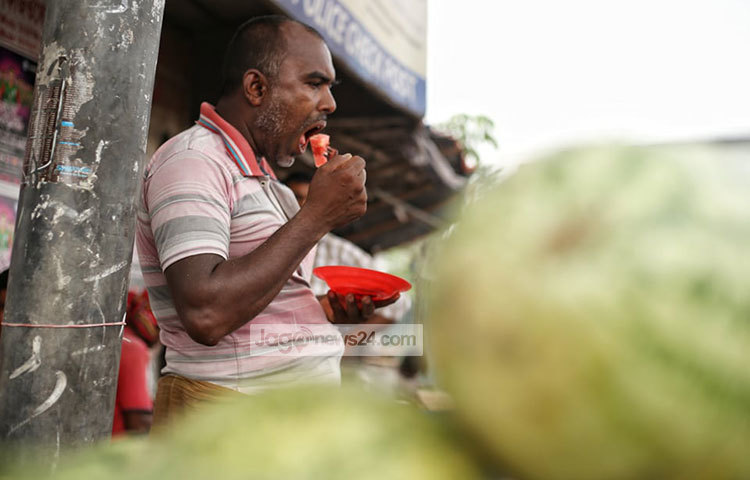 তরমুজের স্বাদ নিচ্ছেন একজন। ছবি: মাহবুব আলম