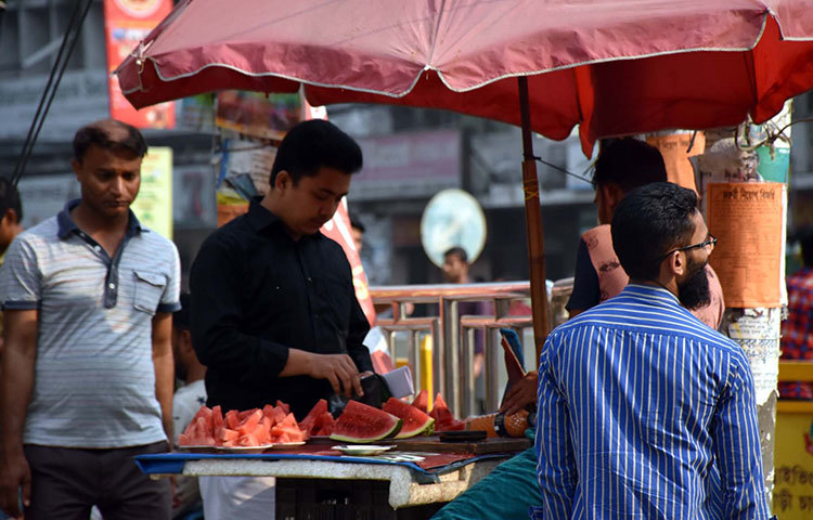 গরমে পথচারীদের পিপাসা মেটাতে ফুটপাতে বিক্রি হচ্ছে রসালো তরমুজ। ছবি: বিপ্লব দিক্ষিৎ
