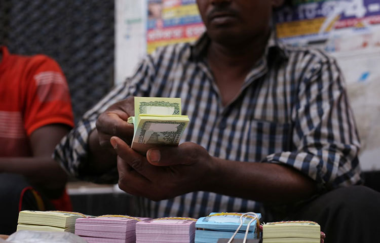 টাকা সাজিয়ে রাখছেন এক দোকানি। ছবি: মাহবুব আলম