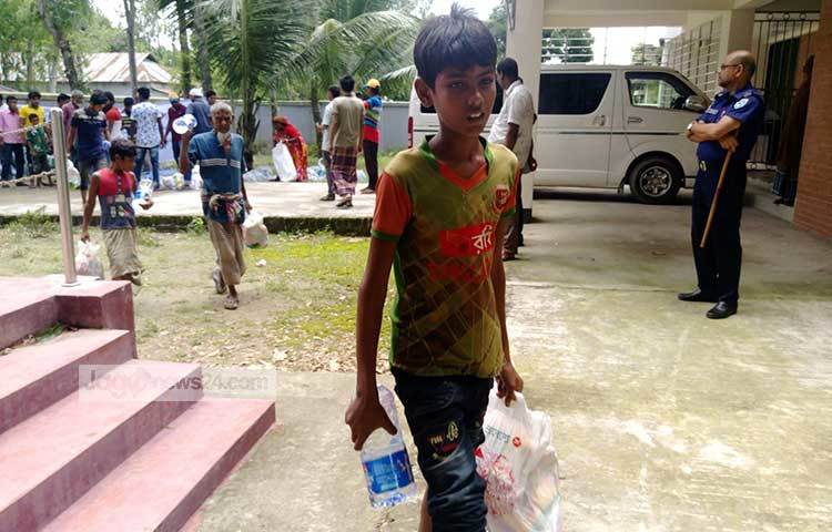 ত্রাণ নিয়ে বাড়ি ফিরছে এক কিশোর। ছবি: মাহবুব আলম