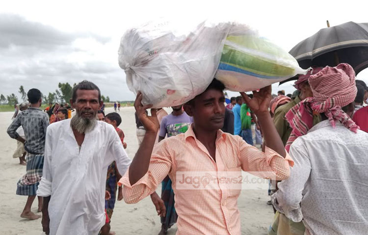 প্রাণ-আরএল গ্রুপের দেয়া ত্রাণ সংগ্রহ করে নিয়ে যাচ্ছে বন্যার্ত মানুষ। ছবি: মাহবুব আলম