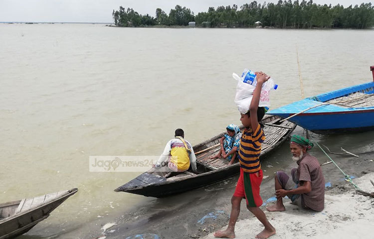 ত্রাণ নিয়ে যাচ্ছে এক শিশু। ছবি: মাহবুব আলম