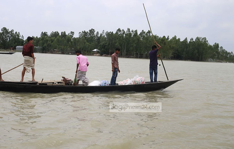 কয়েকজন বন্যার্ত মানুষ নৌকায় করে ত্রাণ নিয়ে আপন গন্তব্যে ফিরছেন। ছবি: মাহবুব আলম