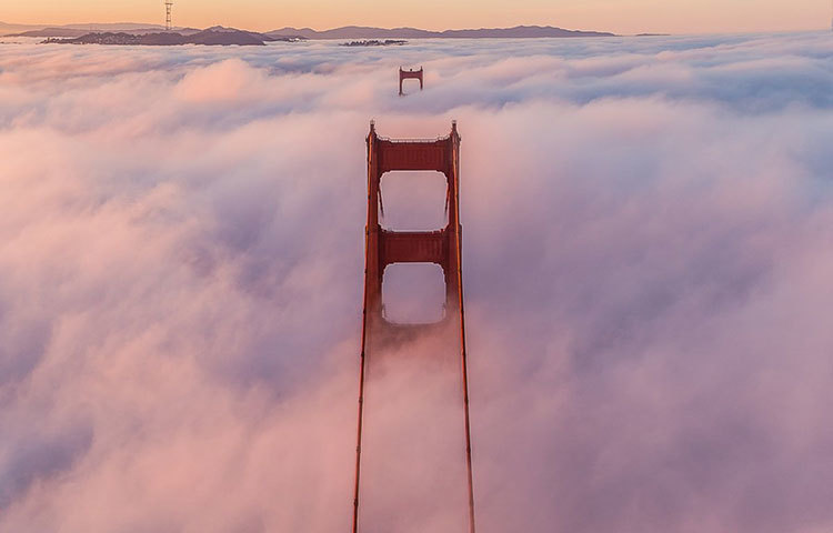 আমেরিকার ক্যালিফোর্নিয়ার গোল্ডেন গেট ব্রিজ। মেঘ ফুঁড়ে উঠে গেছে ব্রিজের মাথা।
