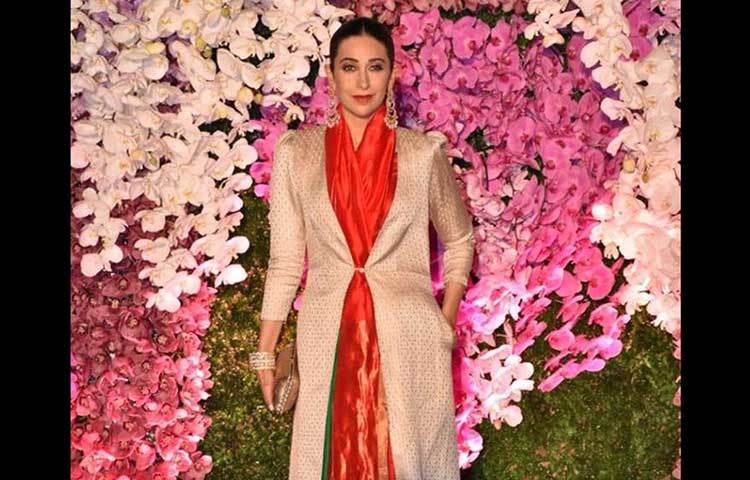 কারিশমা কাপুরের পরনে ছিল লাল সিল্কের শাড়ি। সঙ্গে ছিল লং ডিজাইনার কোট।