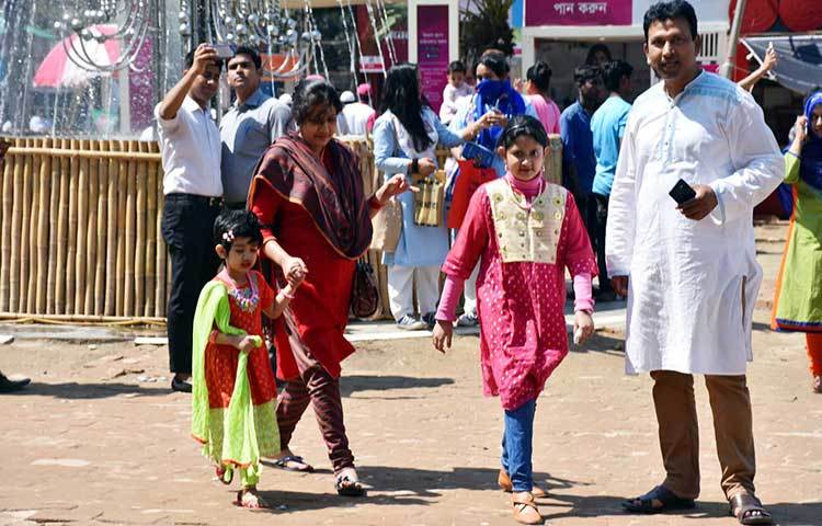 বাবা-মায়ের সঙ্গে মেলায় আসতে পেরে আনন্দিত দুই শিশু। ছবি: বিপ্লব দিক্ষিৎ