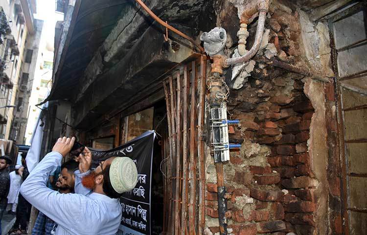 অগ্নিকাণ্ডে ক্ষতিগ্রস্ত বিল্ডিংয়ের ছবি তুলছেন একজন। ছবি: বিপ্লব দিক্ষিৎ